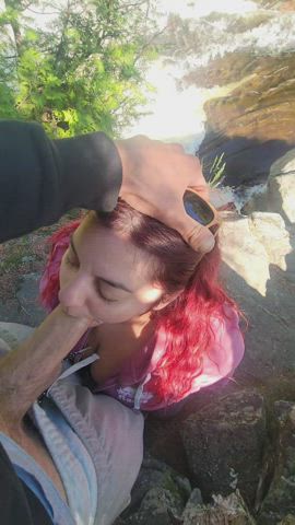 While next to the wild rapids of this waterfall, he fucks her face : video clip