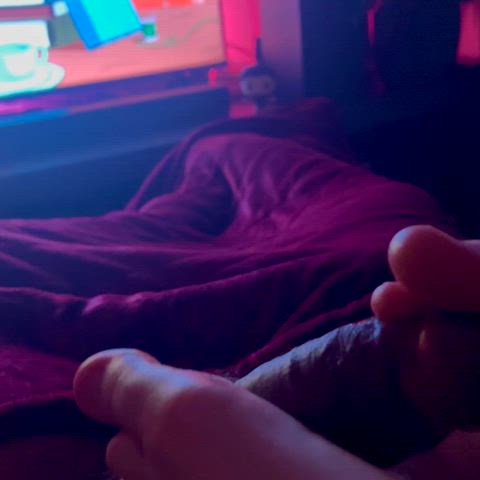 She uses her toes to play with my cock while she watches cartoons : video clip